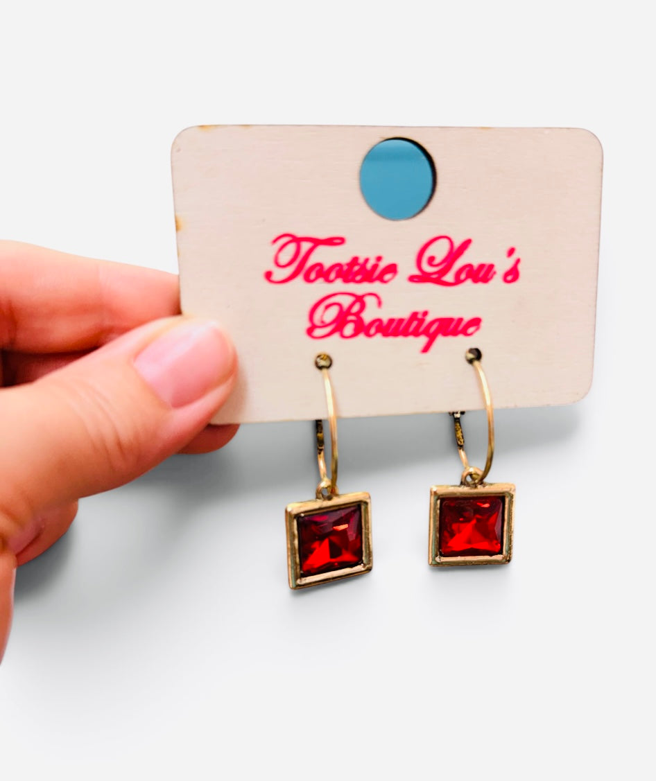 Gold-tone hoops with faceted red square crystal drop earrings.
