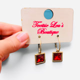 Gold-tone hoops with faceted red square crystal drop earrings.