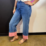 Medium wash straight-leg jeans with bold red and white gingham check cuffs.