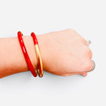Red enamel cuff bracelet with textured brushed gold-tone finish.