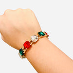 Gold stretch bracelet with red, green, and clear rhinestones.