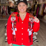 Red cardigan with sequined nutcracker designs and classic button-front silhouette.