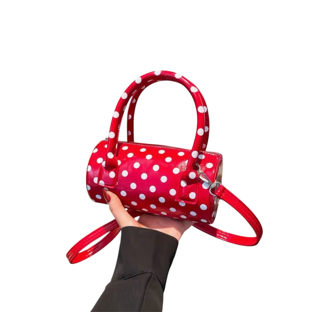 Red polka dot crossbody bag with adjustable strap and top handles.