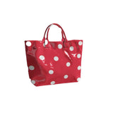 Red tote bag with oversized white polka dots and sturdy top handles.
