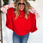 Red knit pullover poncho with relaxed fit and long arm openings for cozy, flowy style.