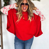 Red knit pullover poncho with relaxed fit and long arm openings for cozy, flowy style.