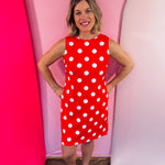 Red sleeveless polka dot dress with oversized bow back detail and side pockets.