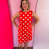 Red sleeveless polka dot dress with oversized bow back detail and side pockets.