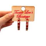 Red hoop earrings with glossy finish and gold star accents lightweight design