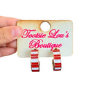 Red and white striped enamel hoop earrings with polished gold-tone finish.

