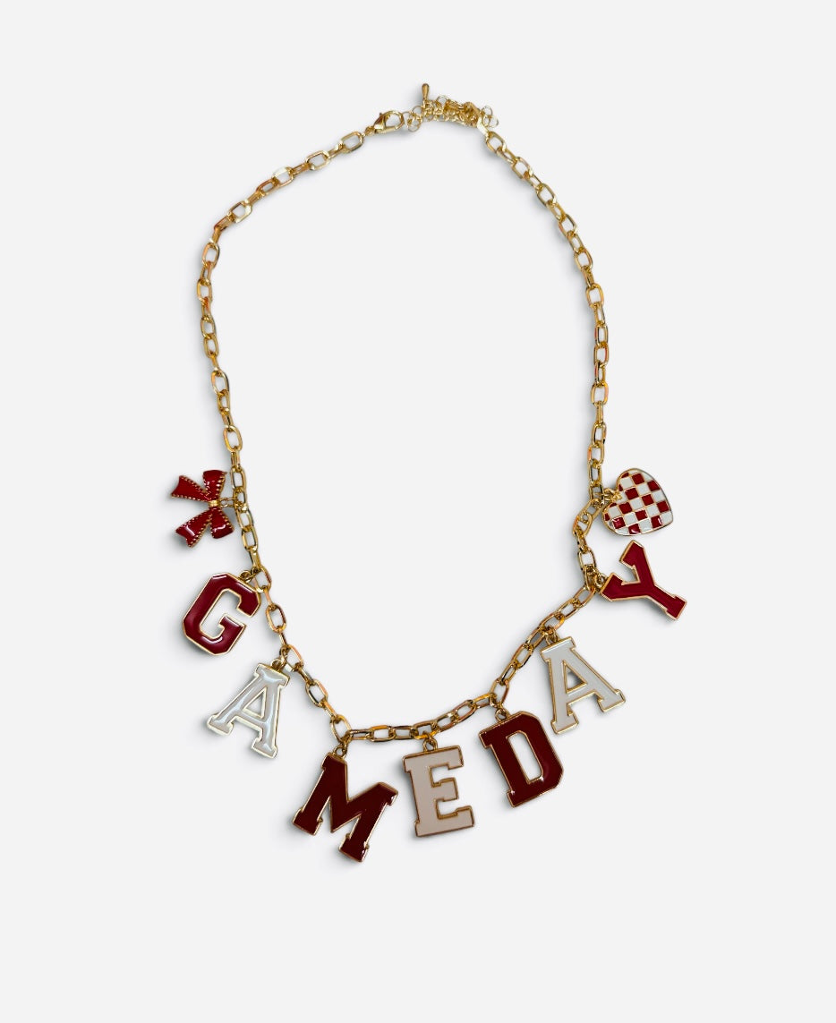 Red and white game day necklace with gold-tone chain, letter, bow, and checkered heart charms.