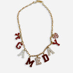 Red and white game day necklace with gold-tone chain, letter, bow, and checkered heart charms.