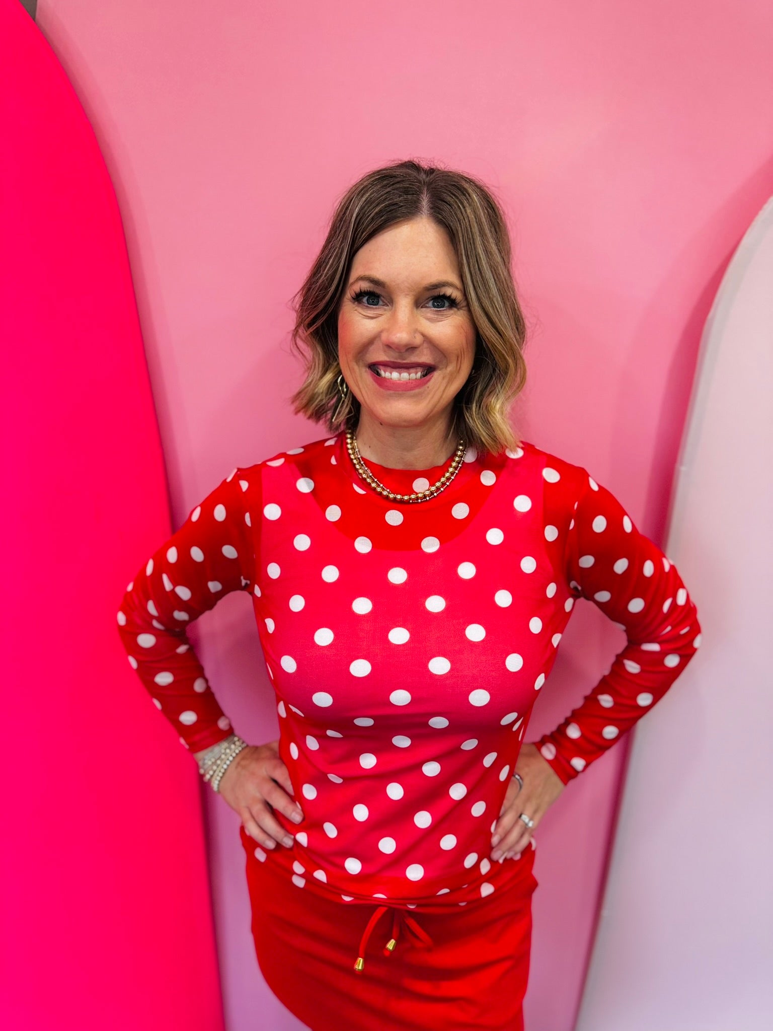 Red mesh top with white polka dots and mock neckline.