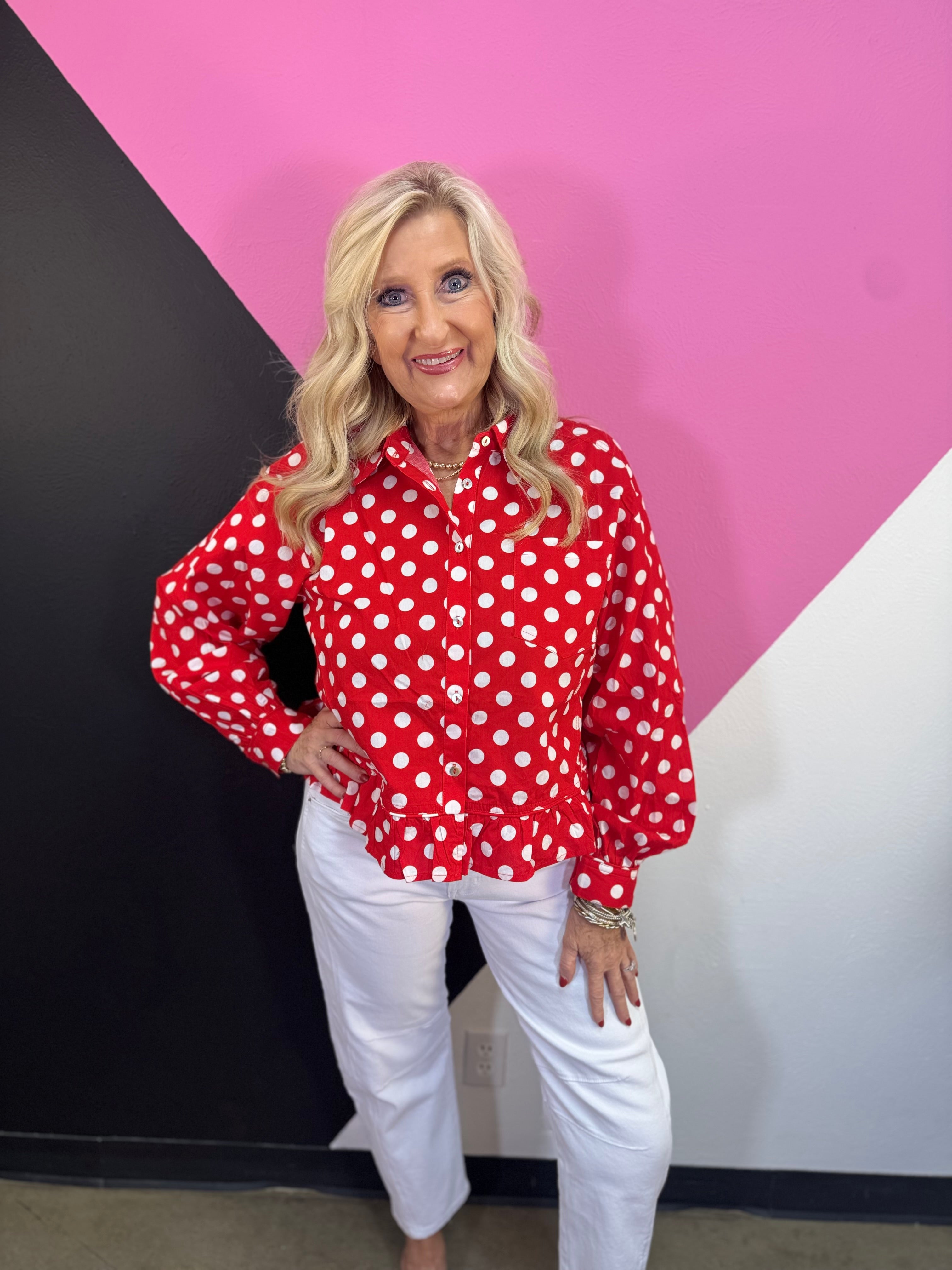 Red and white polka dot button down top with long sleeves and ruffle hem