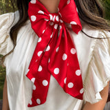Red and white silky polka dot scarf with versatile styling options.