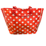 Red PVC tote bag with white polka dots, sturdy top handles, interior pockets, and Velcro closure.