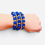 Royal blue beaded bracelet stack with polished gold-tone beads and stretch fit.