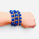 Royal blue beaded bracelet stack with polished gold-tone beads and stretch fit.