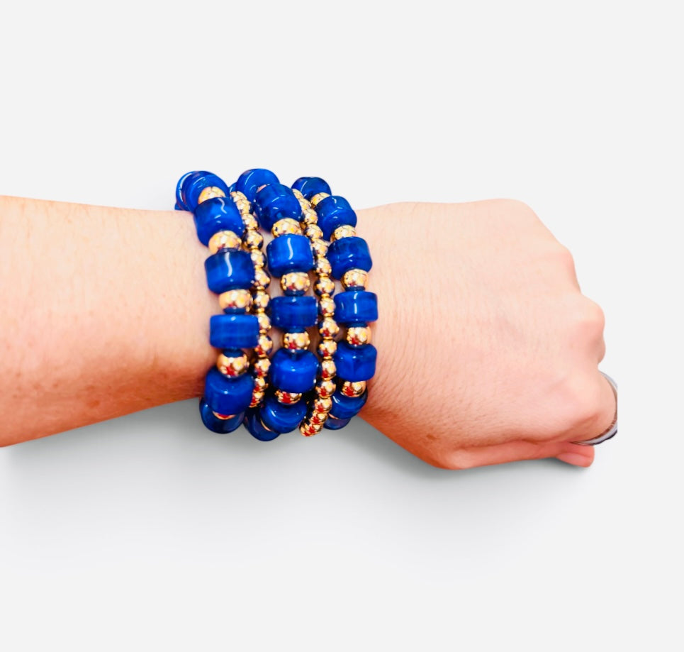 Royal blue beaded bracelet stack with polished gold-tone beads and stretch fit.