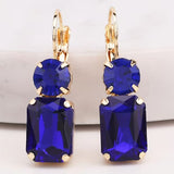Royal blue rectangular rhinestone dangle earrings on matching circular rhinestone studs.