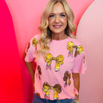Pink top with sequined pencil and bow designs on front.