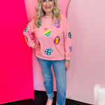 Blushed pink sweatshirt with colorful sequined Easter egg patches and ribbed neckline cuffs and hem