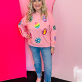 Blushed pink sweatshirt with colorful sequined Easter egg patches and ribbed neckline cuffs and hem