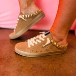 Camel suede backless sneakers with metallic studs, star details, and textured laces.