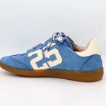 Sky-blue suede Retro 25 sneakers with cream accents, stitched detail, and gum sole.