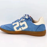 Sky-blue suede Retro 25 sneakers with cream accents, stitched detail, and gum sole.