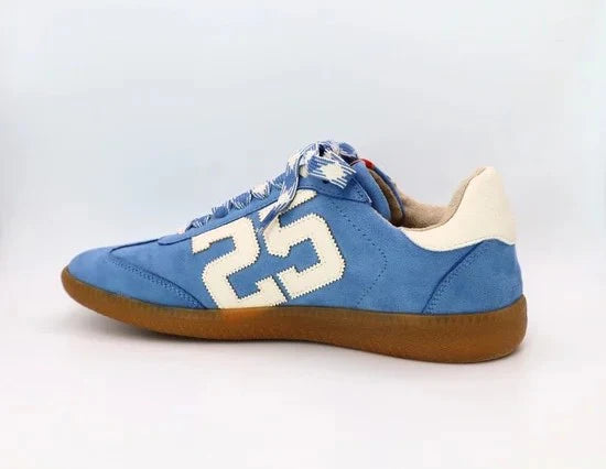 Sky-blue suede Retro 25 sneakers with cream accents, stitched detail, and gum sole.