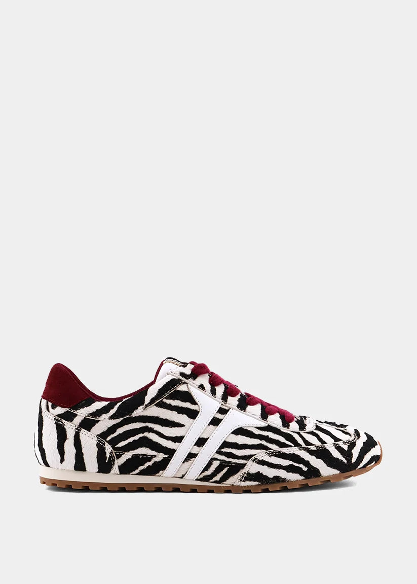 Zebra-print hair sneakers with burgundy accents and gum sole.