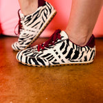 Zebra-print hair sneakers with burgundy accents and gum sole.