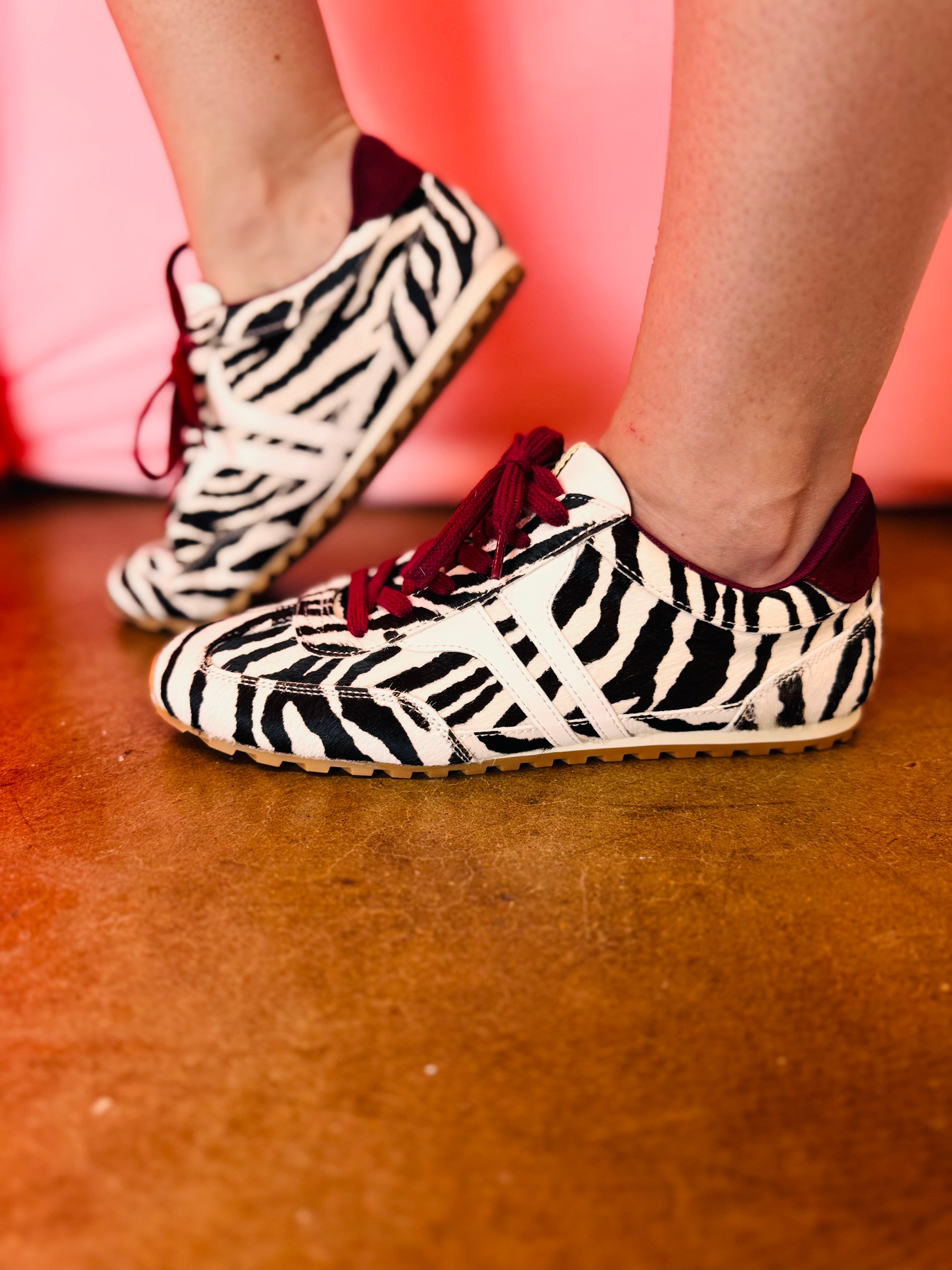 Zebra-print hair sneakers with burgundy accents and gum sole.