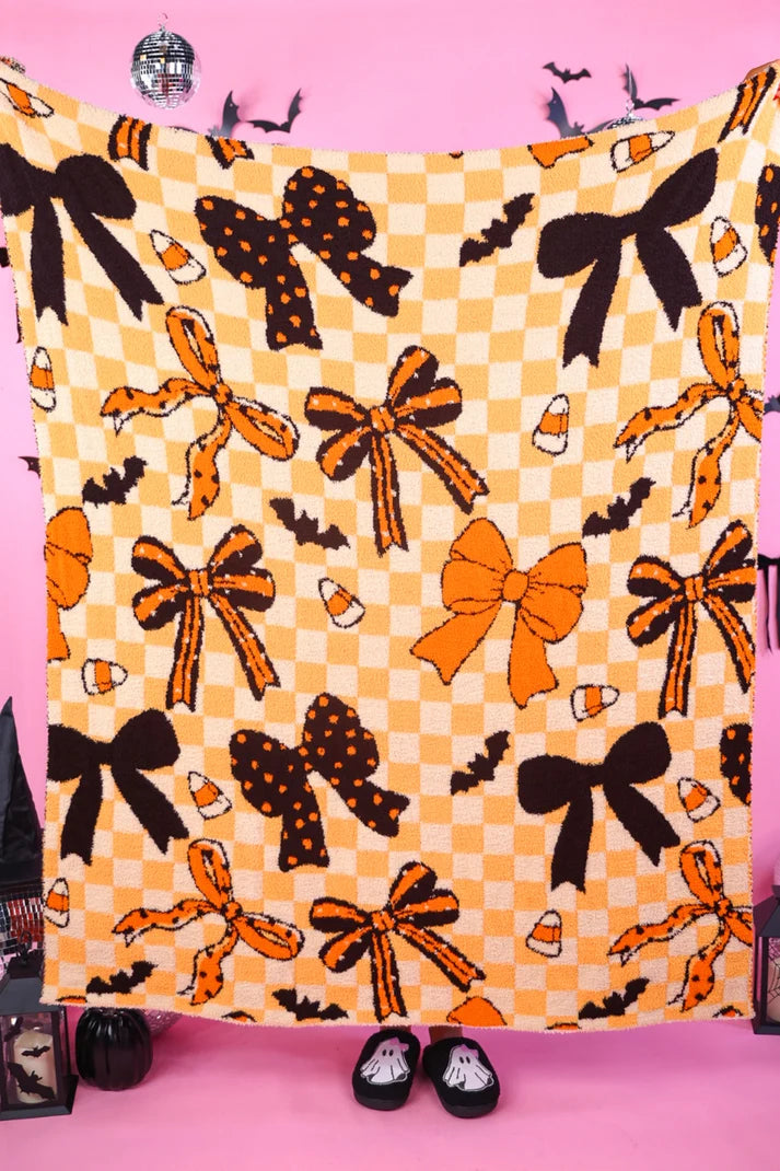 Halloween blanket with bows, bats, candy corn and checkerboard accents.