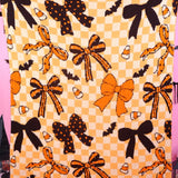 Halloween blanket with bows, bats, candy corn and checkerboard accents.