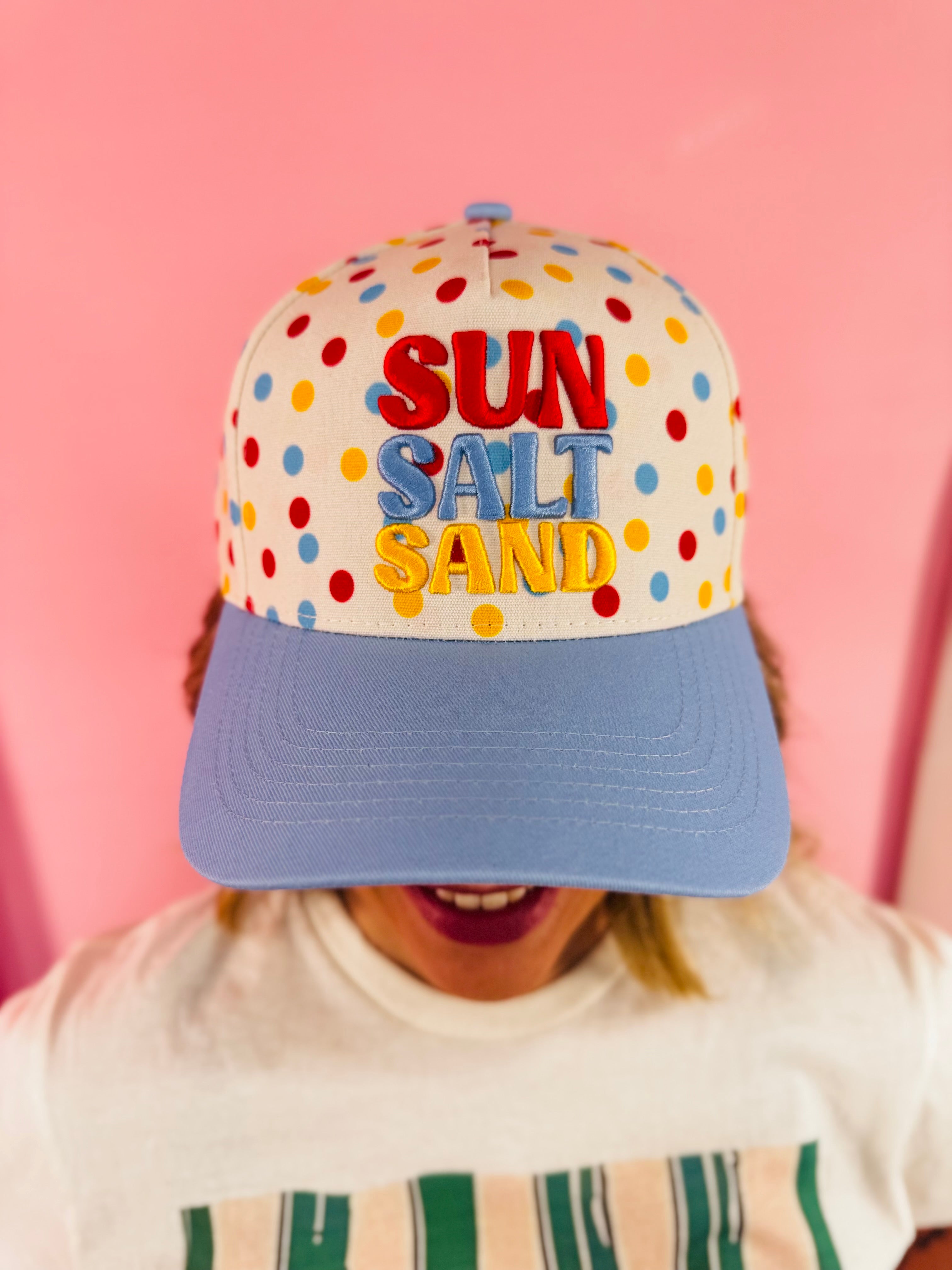 White polka dot hat with blue bill and colorful Sun Salt Sand embroidery.