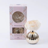 Sweet Grace holiday flower diffuser with pink blooming flower and metallic vase.