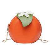 Orange fruit shaped crossbody bag with green leaves and gold chain strap.