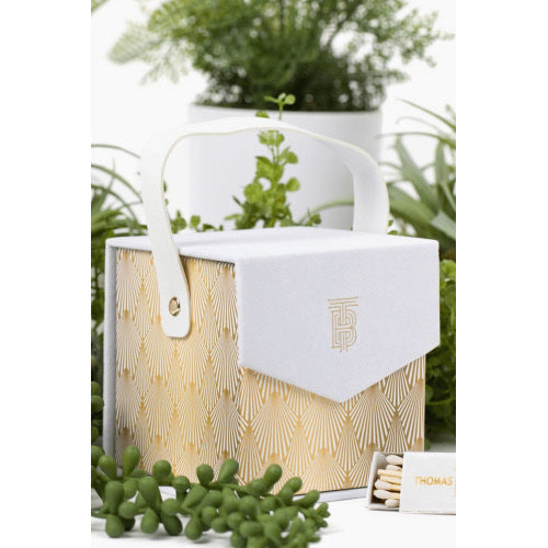Thomas Blonde - A 12 oz. moonstone-infused candle in a white and gold gift box with matches.