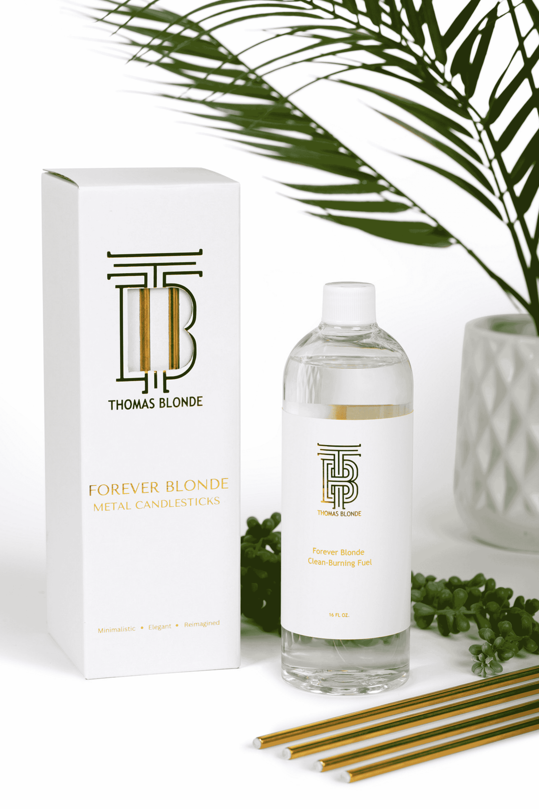 Thomas Blonde - Four sleek, gold metal candlesticks are shown next to a 16 oz bottle of clean-burning fuel oil.