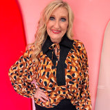 Leopard print blouse with black trim and tie neckline.