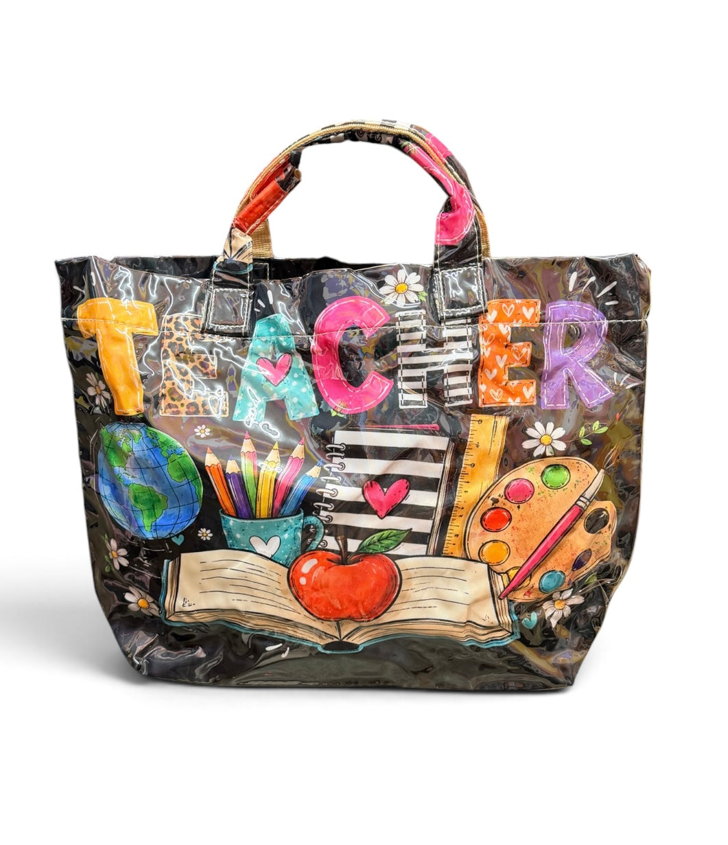 Teacher tote bag with colorful patchwork lettering, books, globe, pencils, ruler, and apple graphics.