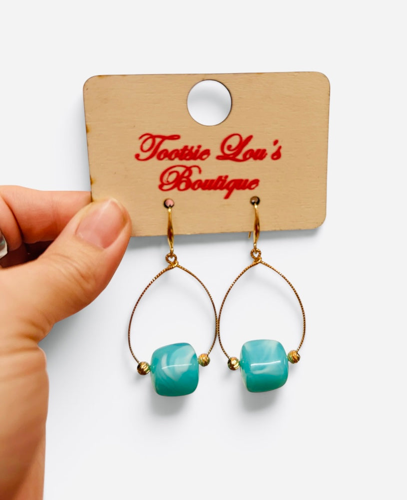 Teal marbled bead drop earrings with gold-tone teardrop frames and gold accents.