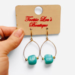 Teal marbled bead drop earrings with gold-tone teardrop frames and gold accents.