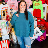 Plus-size teal ribbed boat neck long sleeve top with raw edge detailing.