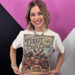 Cream Thanksgiving tee with dressed-up turkeys, colorful chairs, vintage artwork, and sparkling details.
