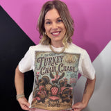 Cream Thanksgiving tee with dressed-up turkeys, colorful chairs, vintage artwork, and sparkling details.