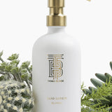 White glass hand lotion bottle with gold pump in Blonde signature scent.