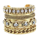 Antique gold four-stack cuff with clear crystals, braided details, polished links, and chunky chain accents.